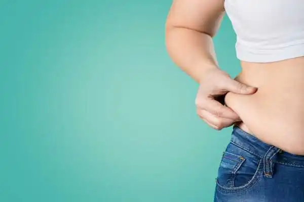 Image of woman pinching her love handles to show weight gain Wigan